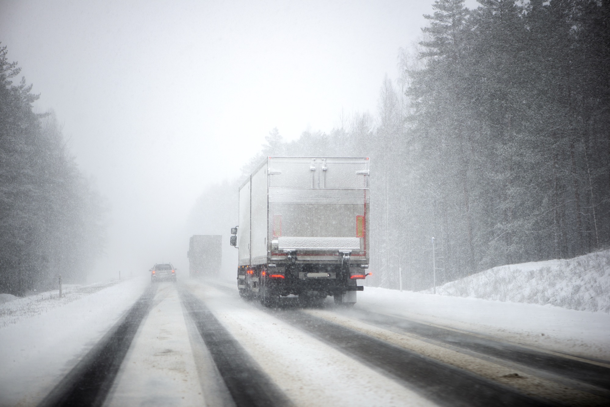Camion vu de l'arrière dans une tempête de neige